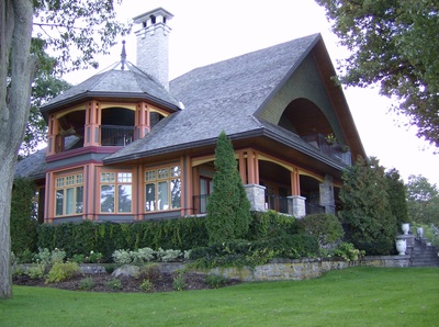 Custom cottage highlighting the upper floor porch and its decorative roof.